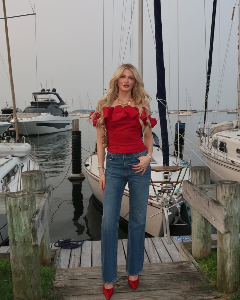 Woman in red ruffle top and straight leg jeans with red heels