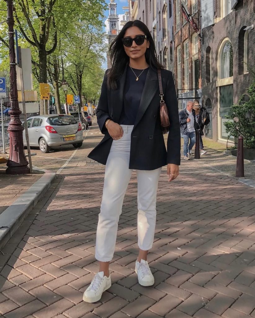 Spring casual outfit with black blazer, navy top, white straight leg jeans and white sneakers
