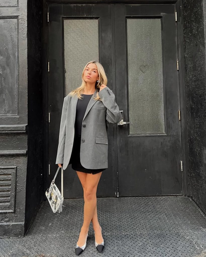 Woman in grey blazer and black mini dress with two-tone
