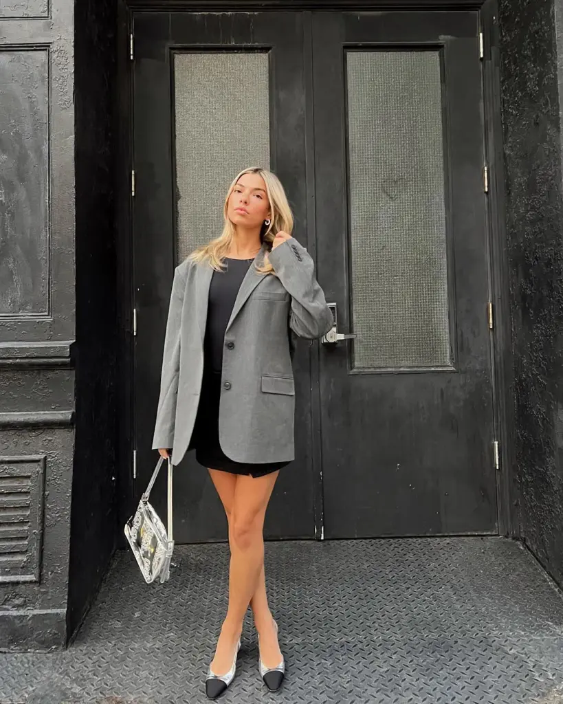 Woman in grey blazer and black mini dress with two-tone

