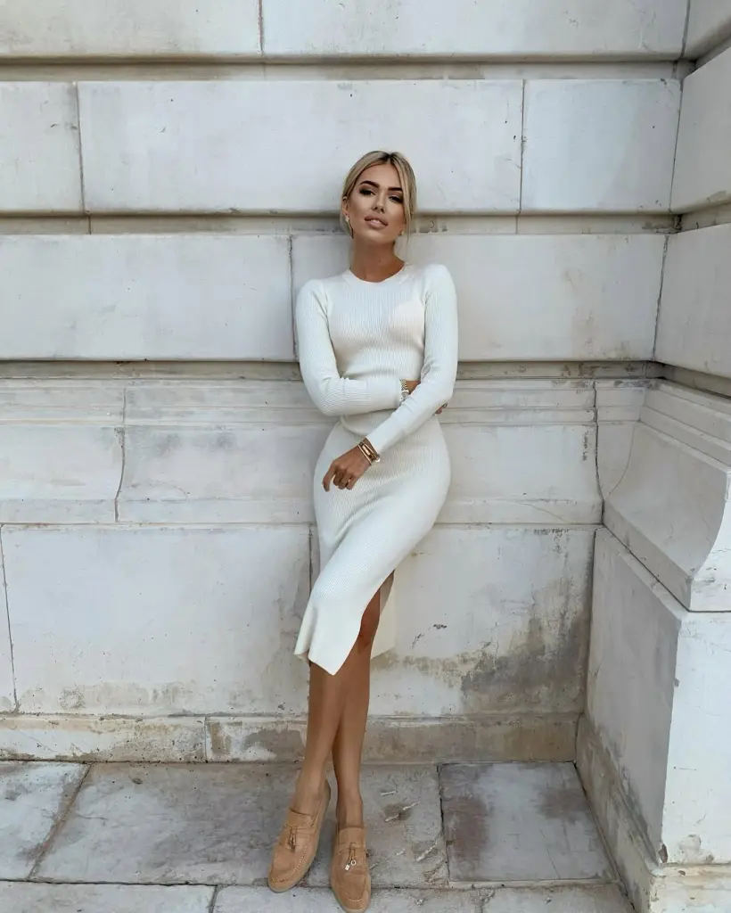 Woman in white ribbed dress with side slit and tan loafers
