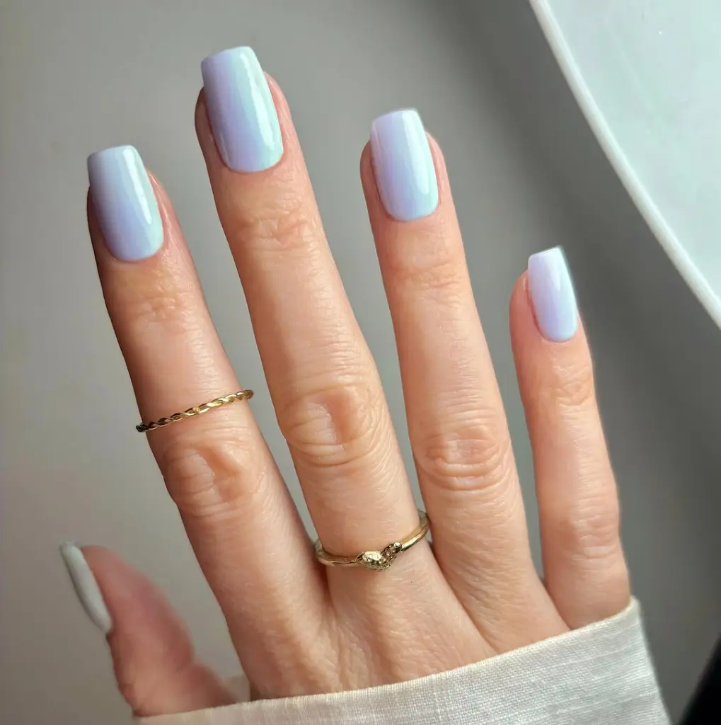 square nails with glossy light blue polish creating a simple, elegant Easter pastel manicure with a soft spring sky-inspired color