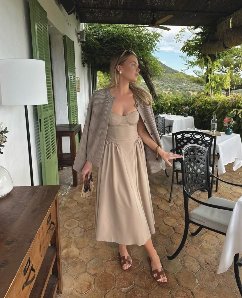 Woman in beige corset dress and knit cardigan
