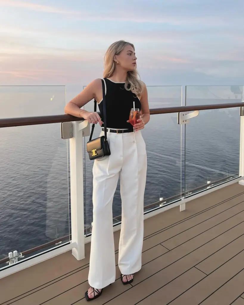 Sunset yacht outfit with black tank top, white wide-leg trousers, black strappy sandals and small black crossbody bag with gold hardware