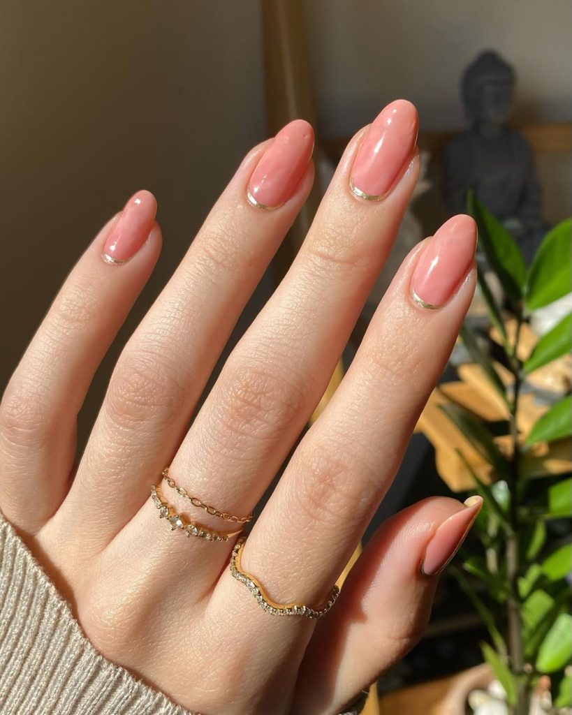 Classy rose quartz pink nails with thin gold lines on almond shaped nails