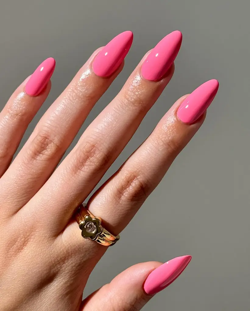 Bright pink polish on long stiletto nails