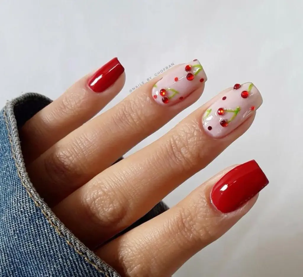 Red nails with 3D cherry gems and milky pink base