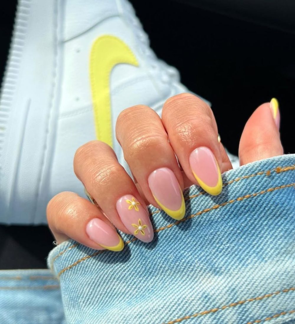 Neutral Pink nails with yellow French tips and yellow flower details