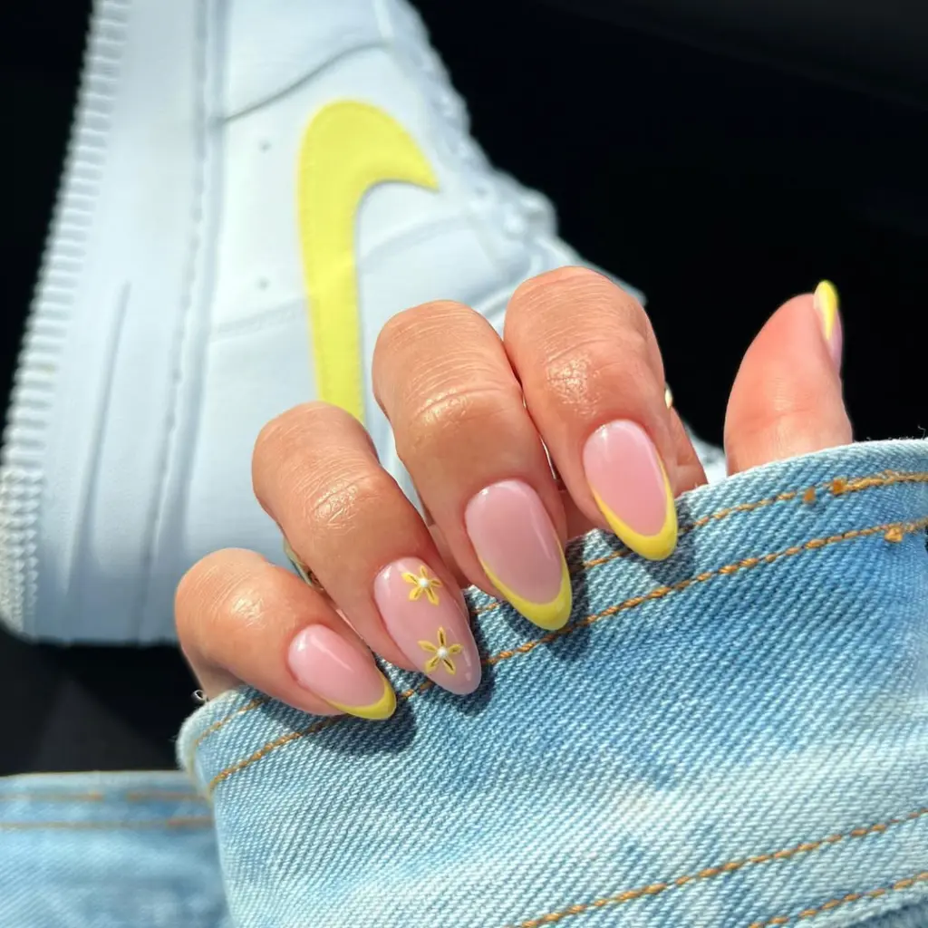 Neutral Pink nails with yellow French tips and yellow flower details
