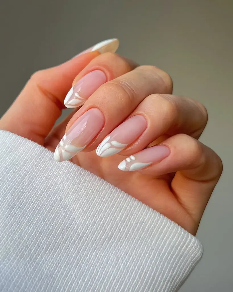 Almond french tip nails with white abstract design
