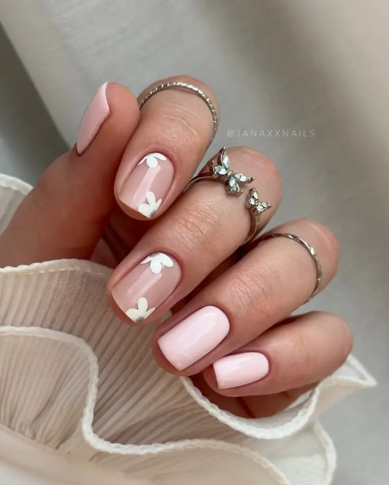 Short baby pink nails with white floral accents and gold details
