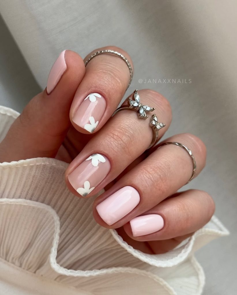 Short baby pink nails with white floral accents
