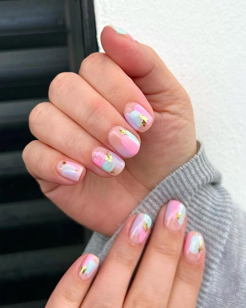 Short pastel watercolor nails with gold foil accents
