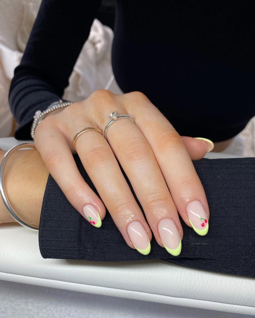 Milky base nails with yellow French tips and red cherry details
