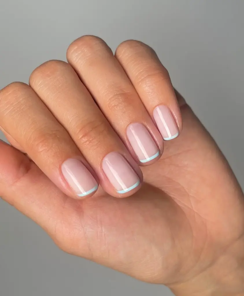 Short french tip nails with blue tips
