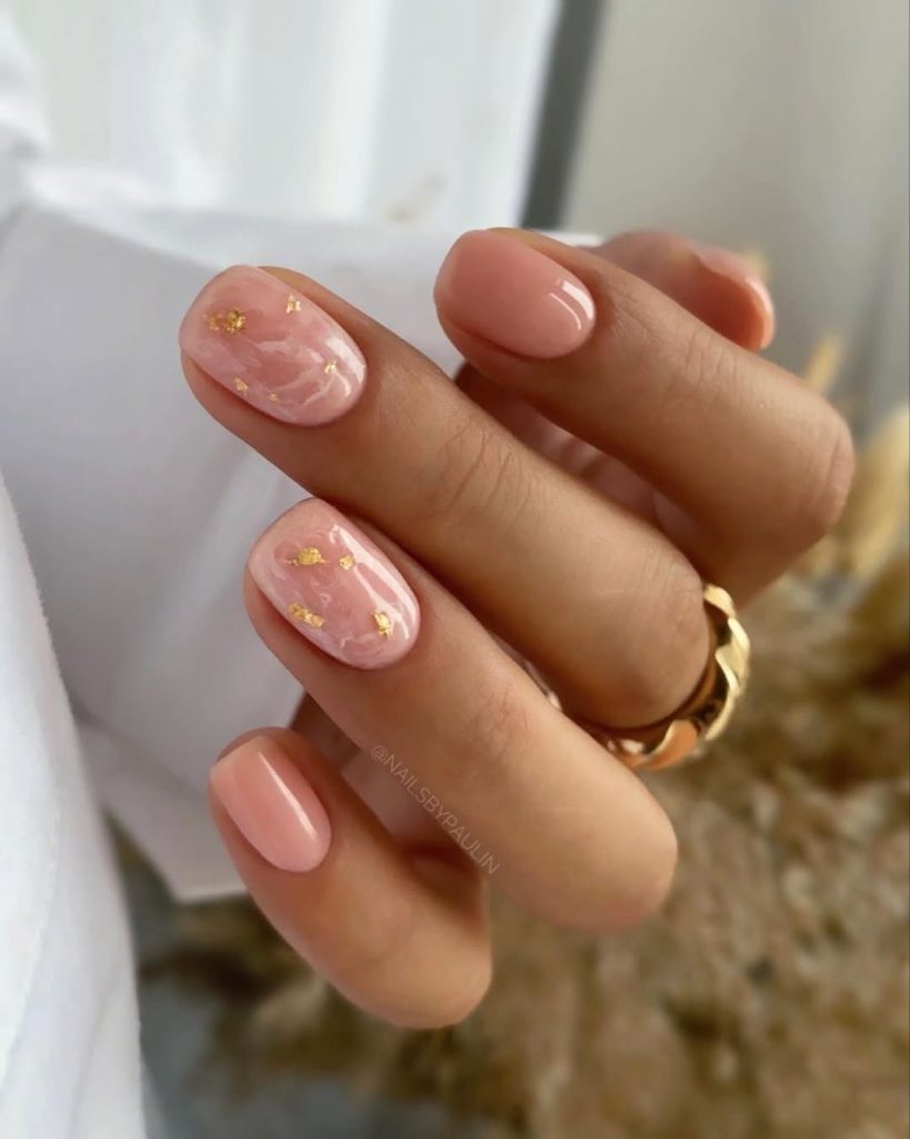 Short pink nails with marble effect and gold details
