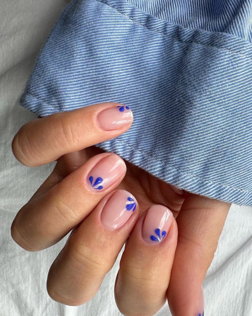 sheer pink short nails with cobalt blue petal accents
