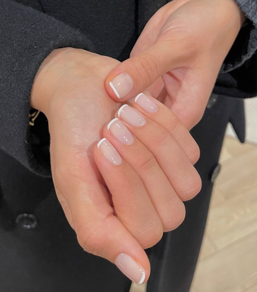 Short square french tip nails with white tips on milky base
