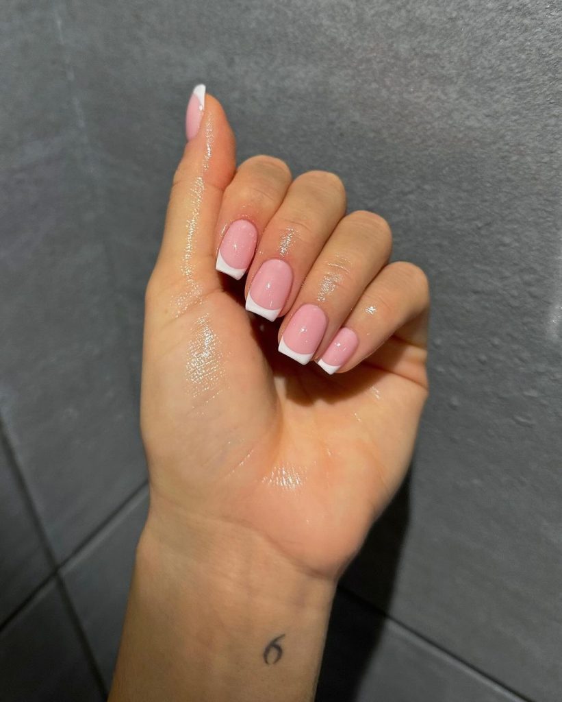 Short square french tip nails with white tips on sheer pink base
