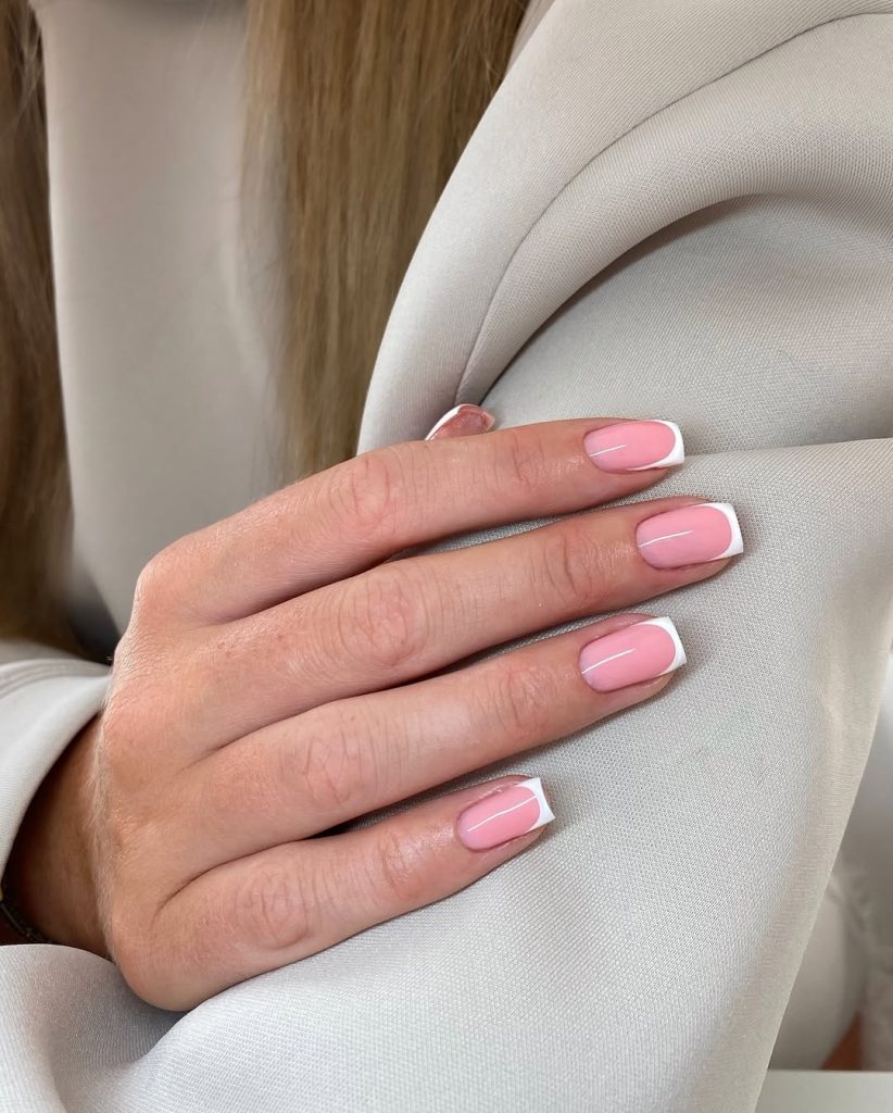 Square french tip nails with white tips on pink base
