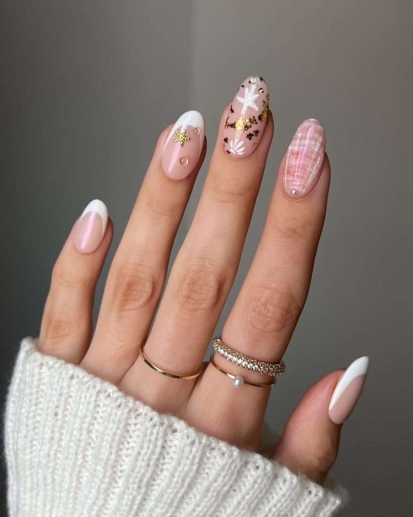 Almond shaped pink nails with white French tips, gold starfish decorations and geometric line patterns 