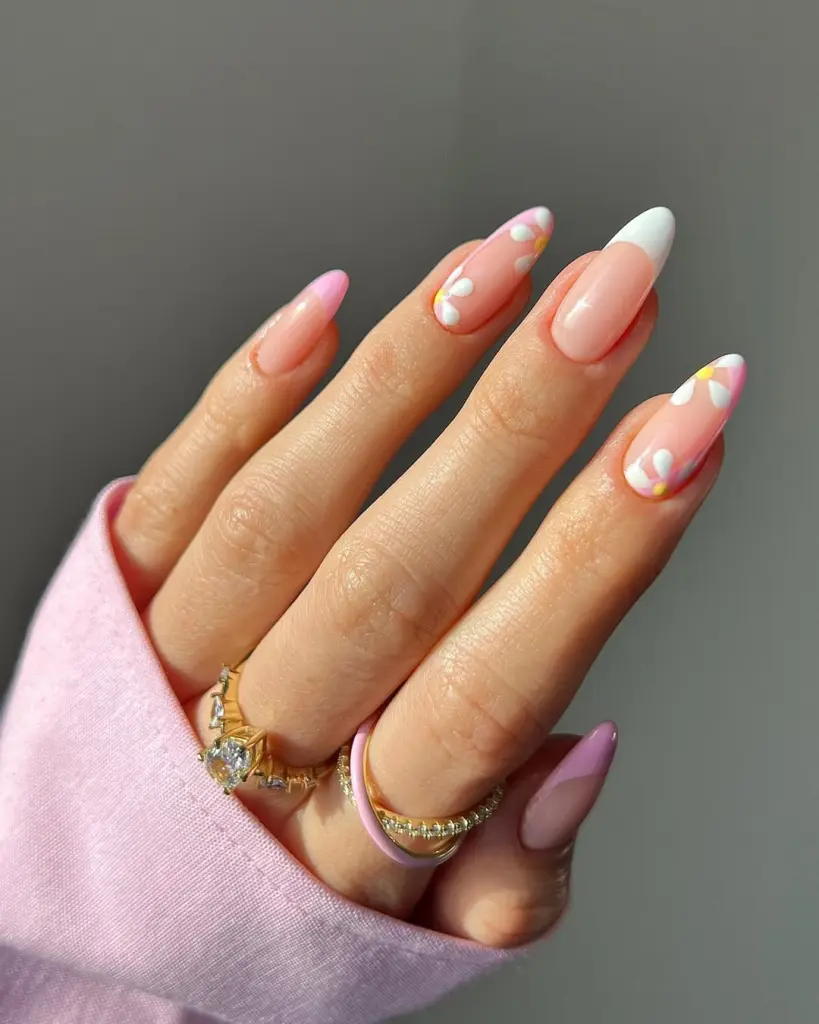 Almond shaped elegant nails with translucent pink base, white and pink French tips and delicate white daisy flowers with yellow centers