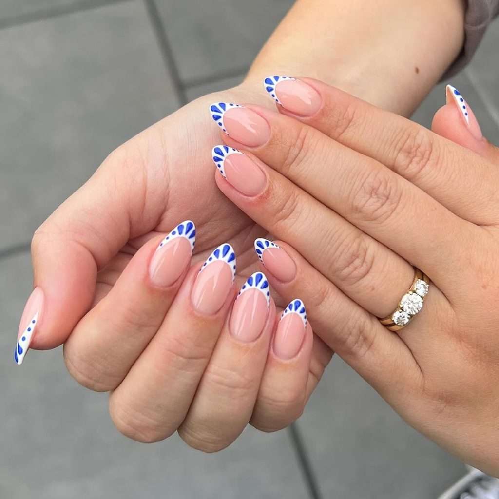 Long almond nails with pink base and royal blue fan design on tips
