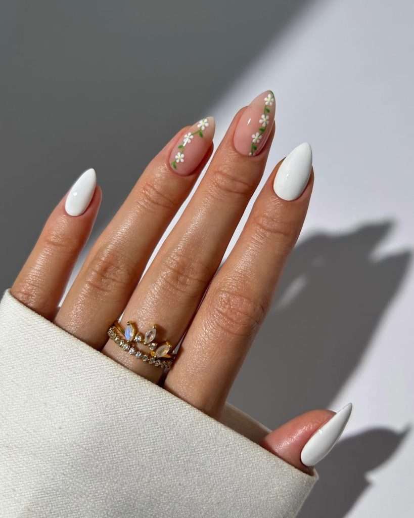 Medium almond nails with white and pink polish and white daisy vine details
