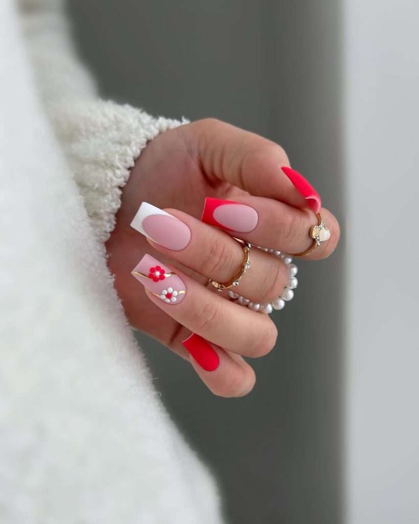 Long square nails with pink base, white and red French tips, and 3D flower accents
