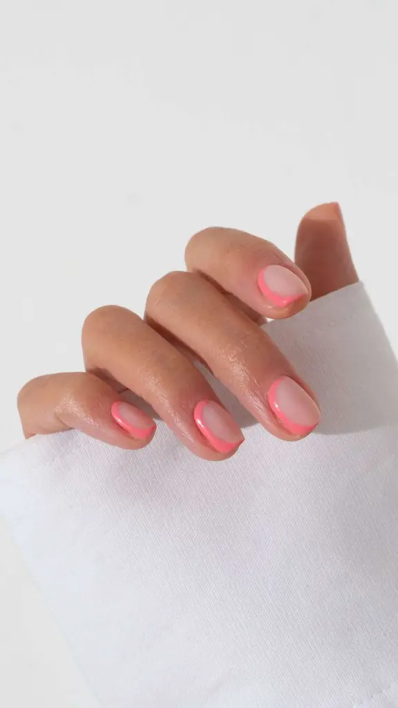 Short natural nails with clear base and neon pink outline French tips

