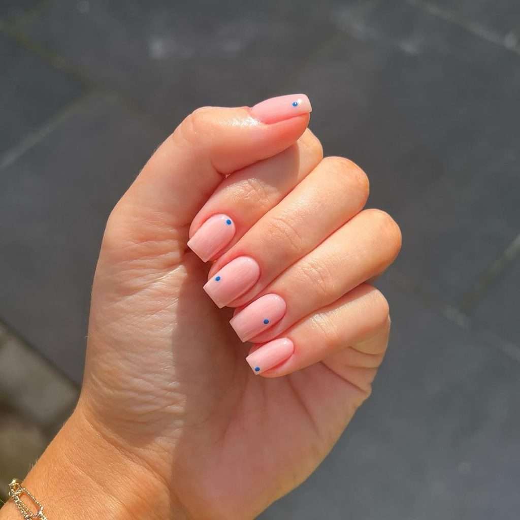  Long square pink nails with small blue dot accents
