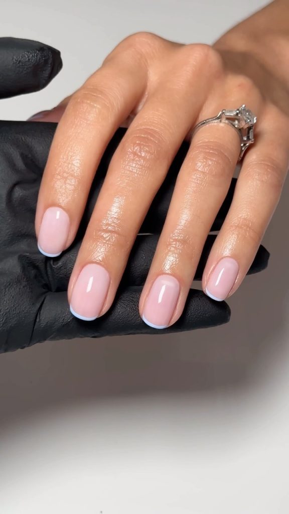 Oval-shaped nails with pink base and light blue French tips creating a fresh spring look
