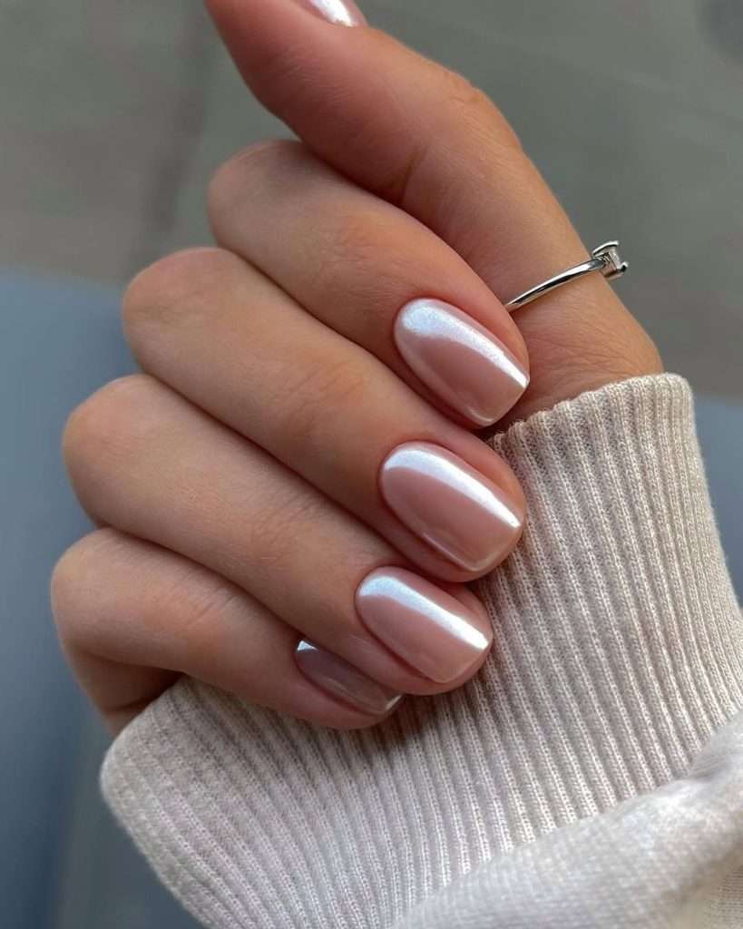 Short square nails painted in iridescent pearl pink chrome polish
