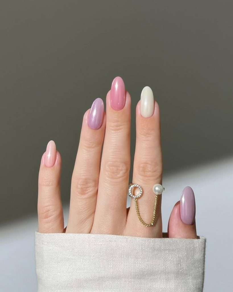Medium almond nails with mixed pastel pink, lavender and pearl white polish
