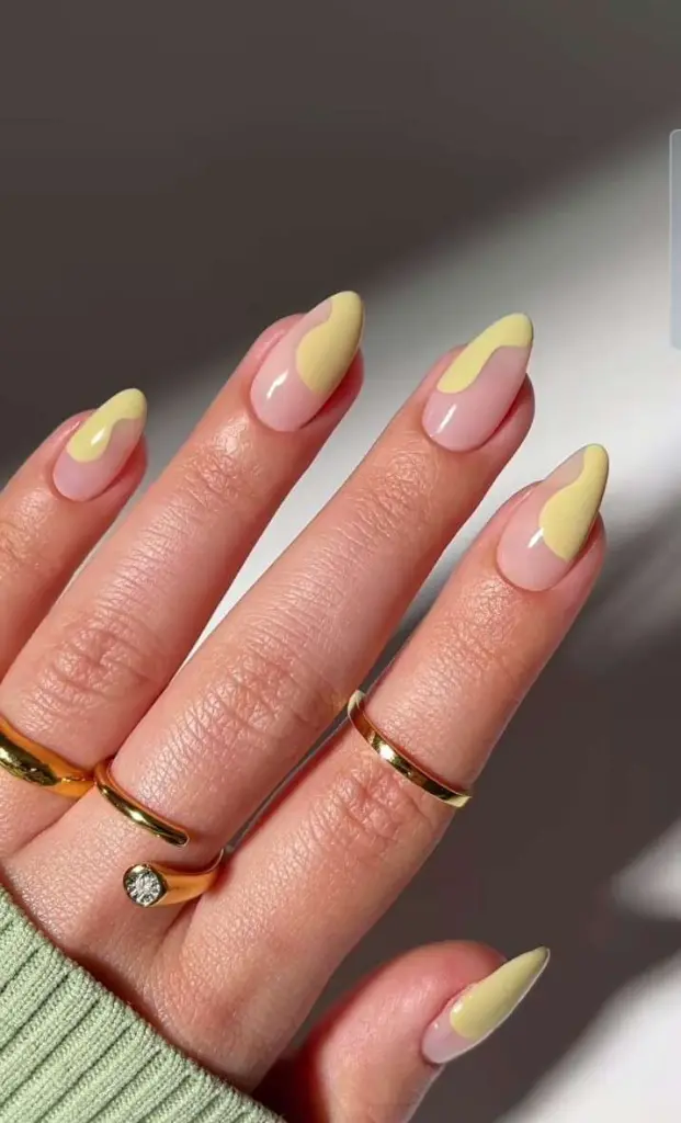 Medium almond nails with pink base and abstract yellow design accents