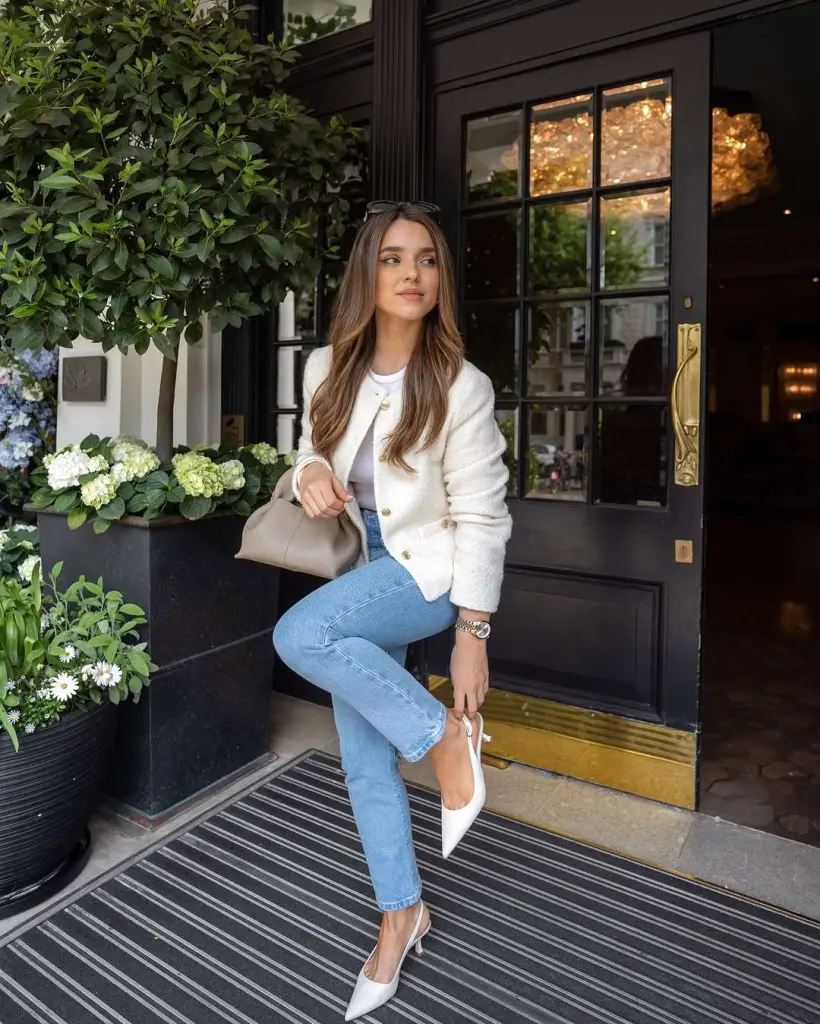 Classy spring outfit with cream boucle jacket, white t-shirt, light wash jeans, white slingback heels and beige shoulder bag