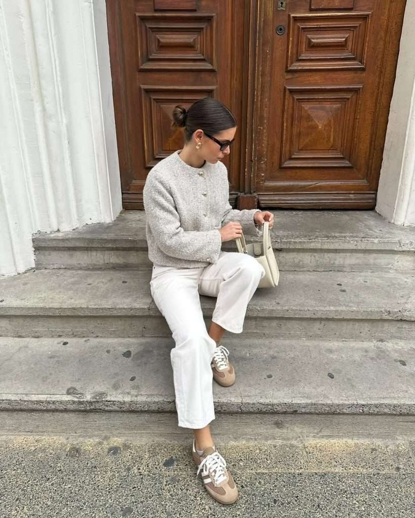 spring outfit with cream tweed jacket, white wide leg jeans, beige sneakers and cream shoulder bag
