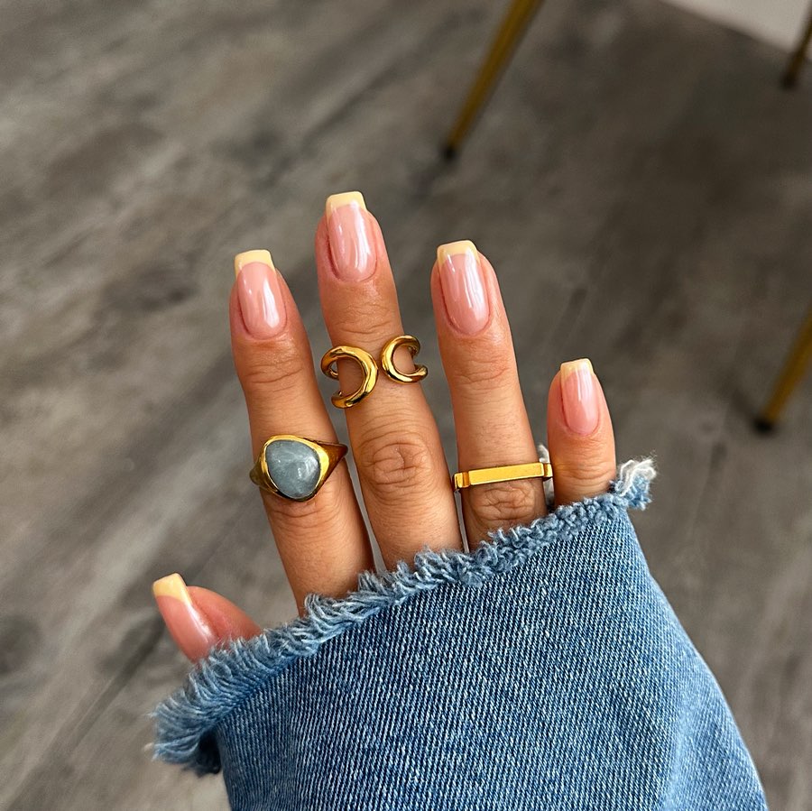 Square-shaped pink nails with pale yellow French tips featuring glazed donut finish
