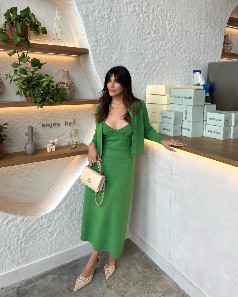 Elegant spring outfit with green structured midi dress, matching green cardigan, cream pointed heels with bow detail and cream quilted shoulder bag