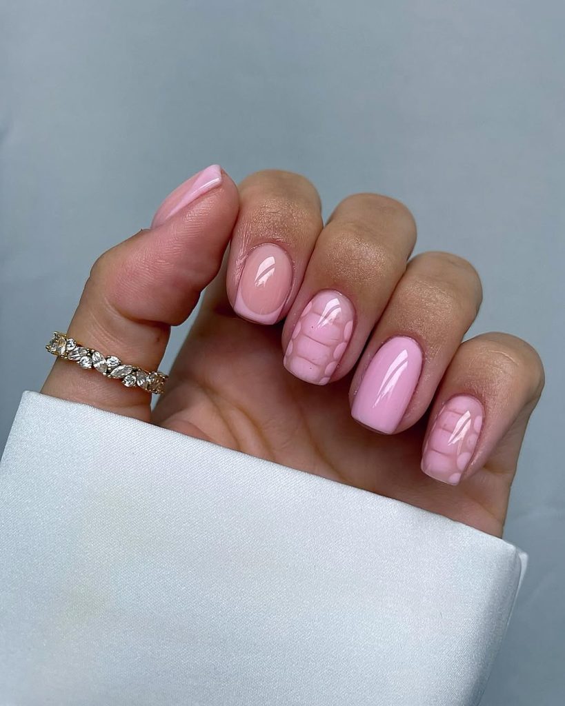 Short nails with pale pink polish and subtle pink petal pattern design on accent nails

