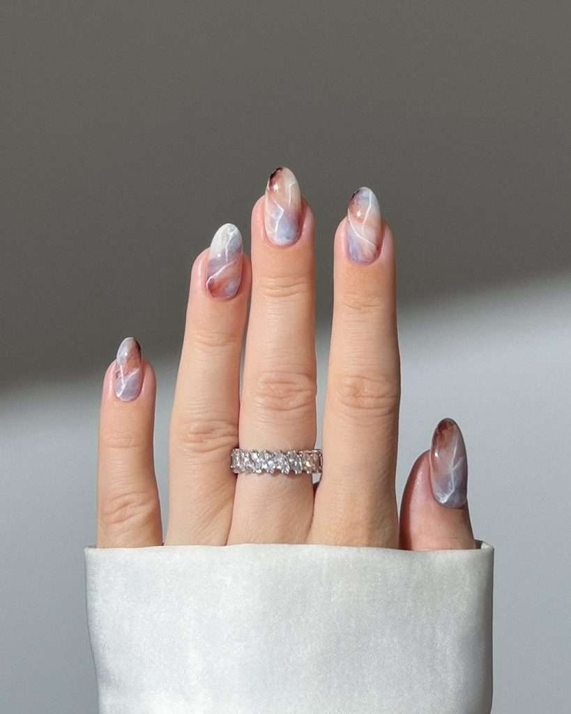 Long almond nails with pink, purple and white marble design
