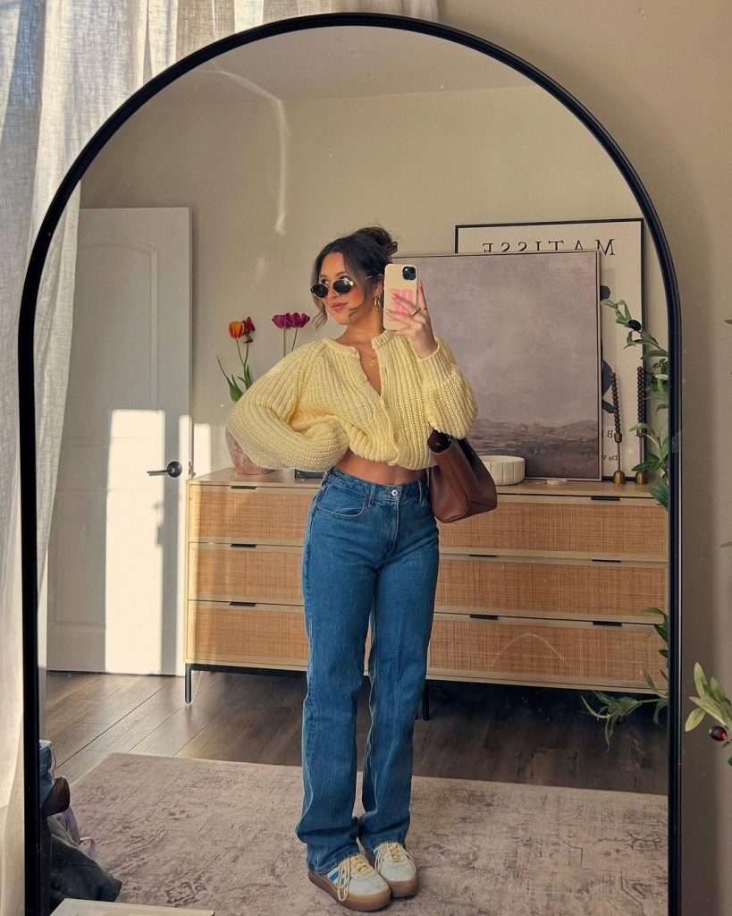spring outfit with yellow cropped cardigan, straight leg jeans, beige sneakers and brown leather shoulder bag

