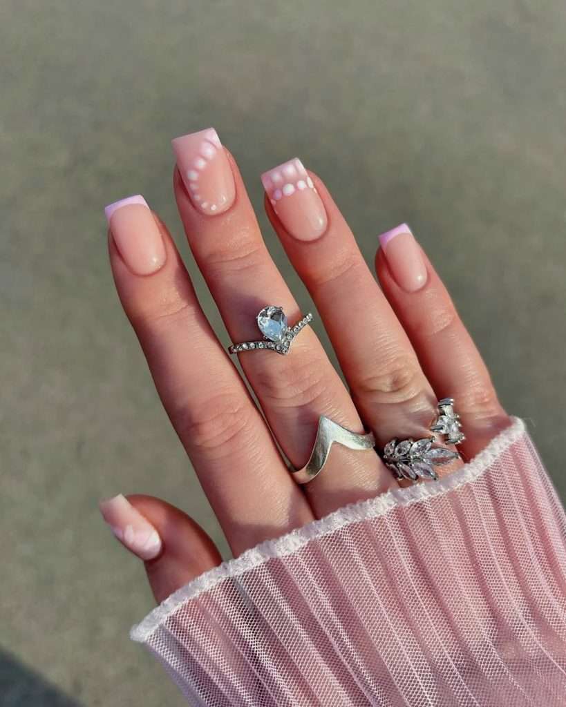 medium square nails with nude base, pink French tips and white dot pattern details