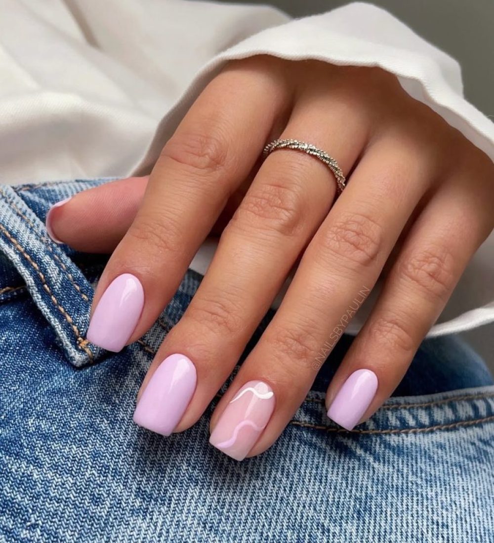 Short square nails with light purple polish and transparent accent nail with white abstract wave design