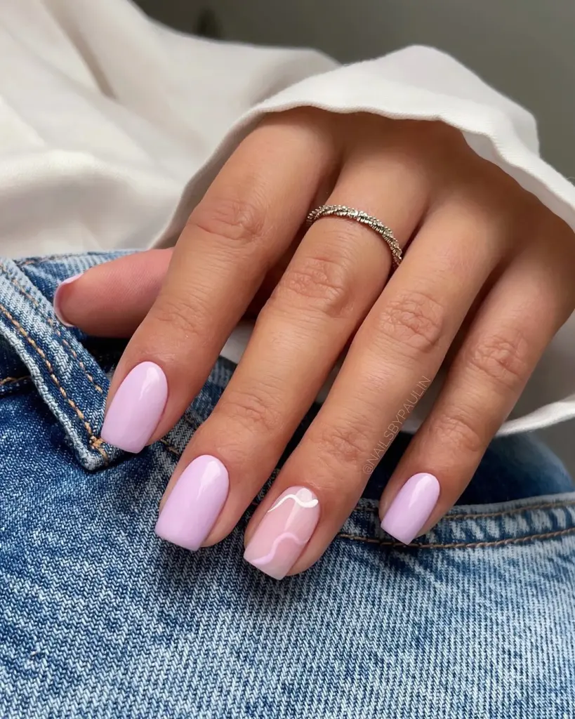 Short square nails with light purple polish and transparent accent nail with white abstract wave design
