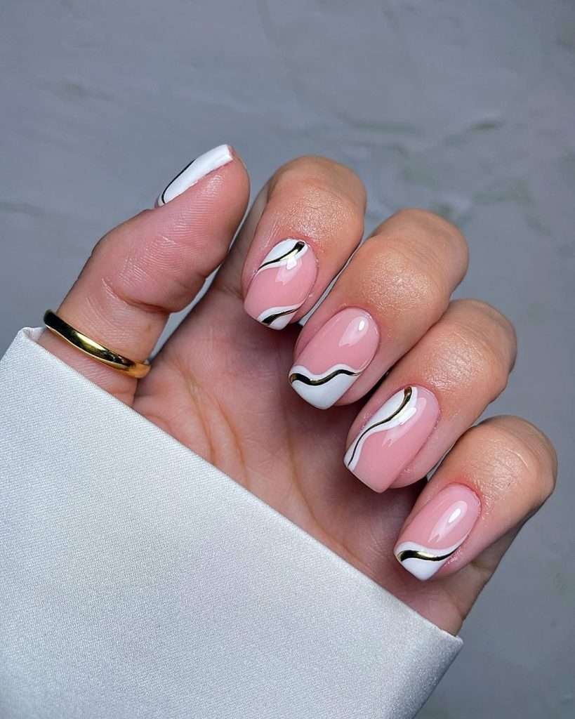 Short square nails with pink base, gold and white wavy line design
