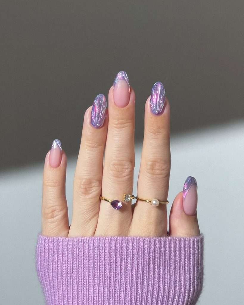 Long almond nails with pink base and chrome purple seashell design on tips
