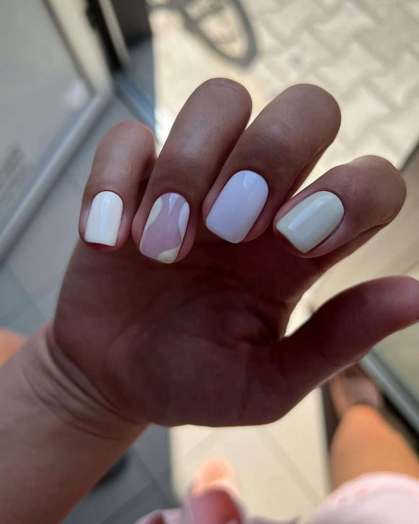Short square white nails with milky swirl design on accent nail