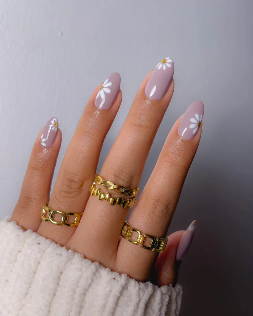 Almond shaped lilac nails with white daisy flowers featuring yellow centers