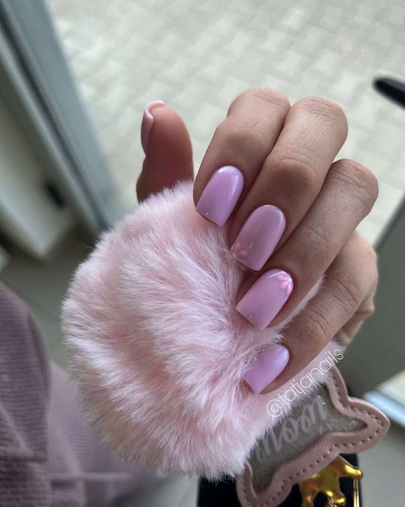 Short square nails in glossy pink with delicate flower accent details